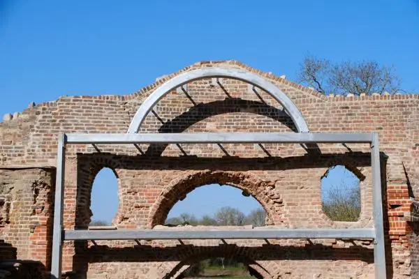 Historic brick facade of the Grotto, with a metal supporting structure in front.