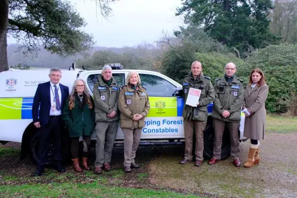 Epping Forest Chair and Keepers with Essex Police, standing by a patrol vehicle.