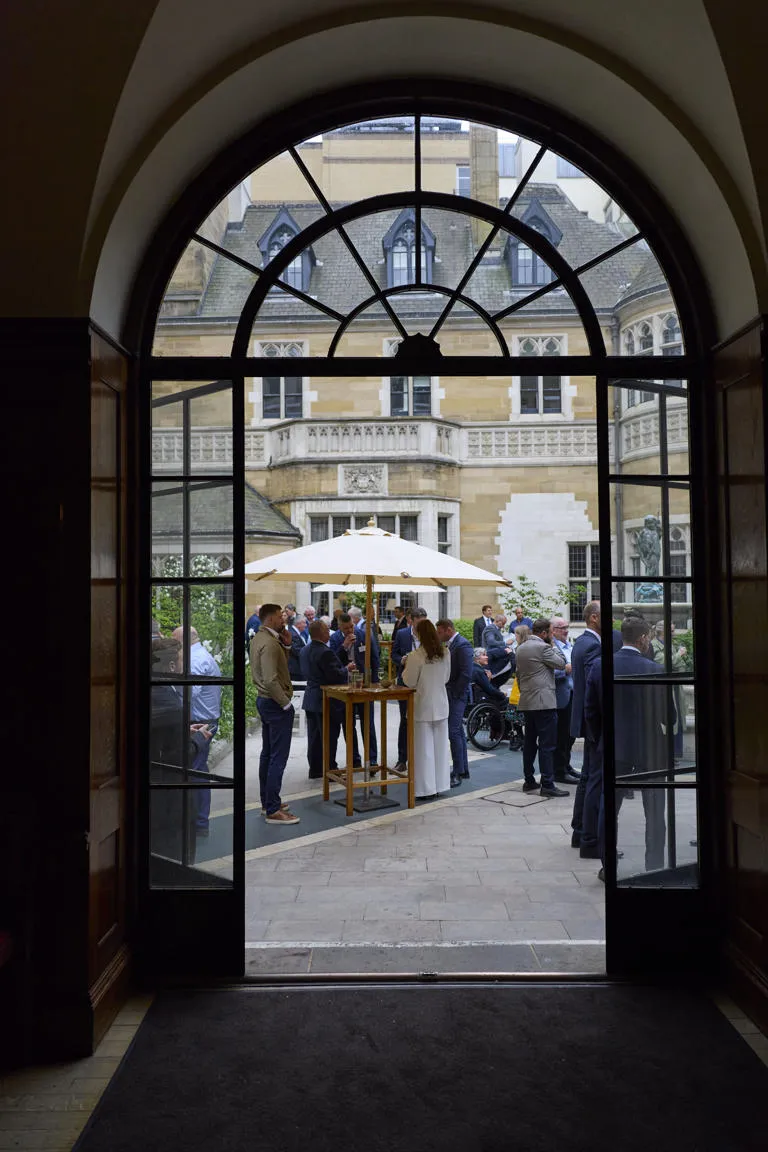 A photo taken through an arched doorway of an outside courtyard during the considerate contractor steelwork scheme reception